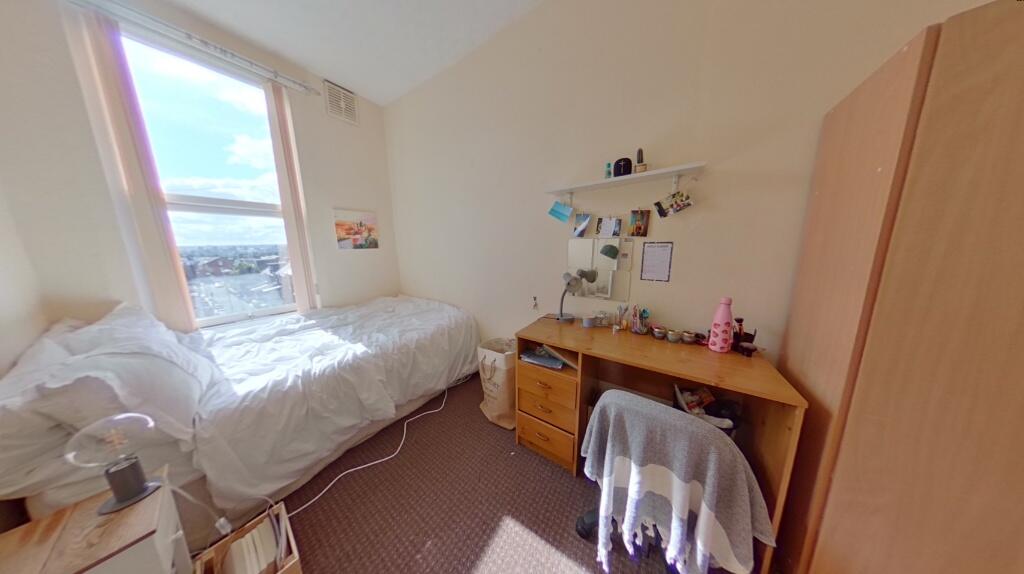 Cozy, bright single bedroom featuring a comfort...