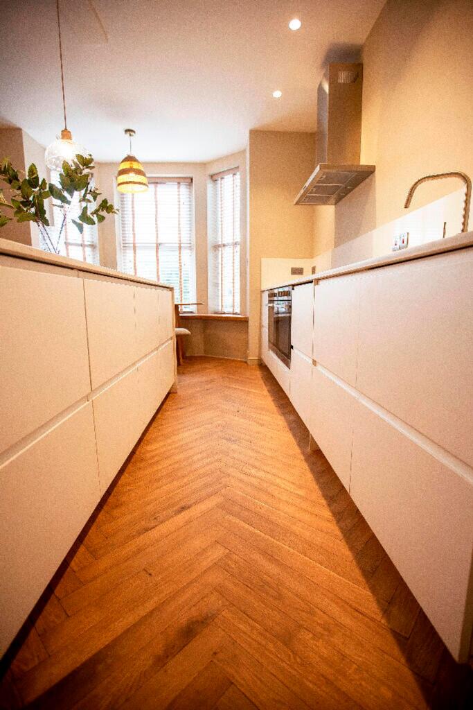 A bright and modern kitchen featuring sleek cab...