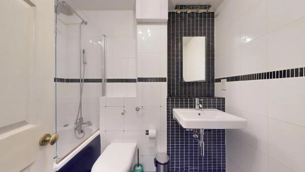 Modern bathroom suite featuring a combined bath...