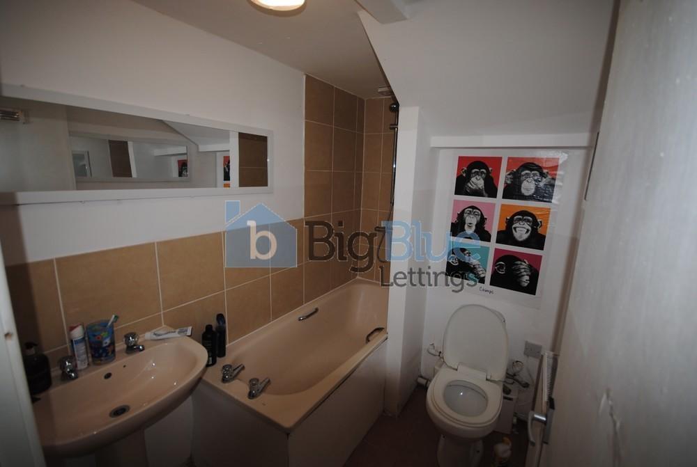 A compact bathroom featuring a bathtub with sho...