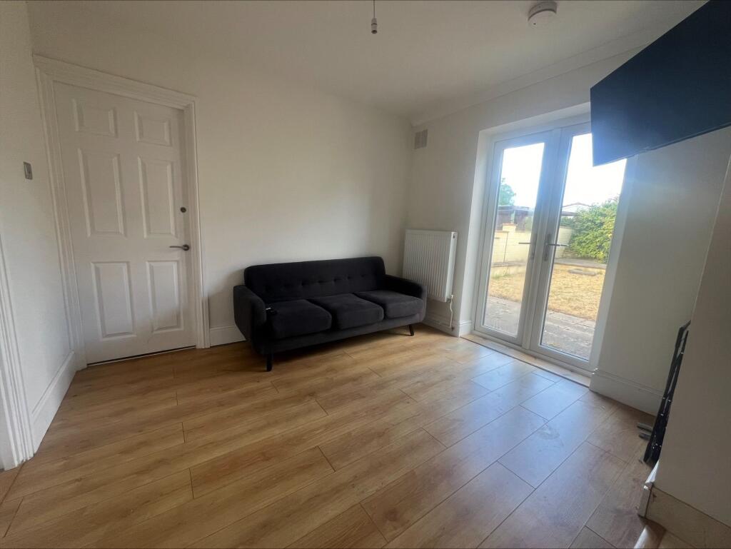 A bright and tidy living room featuring light w...