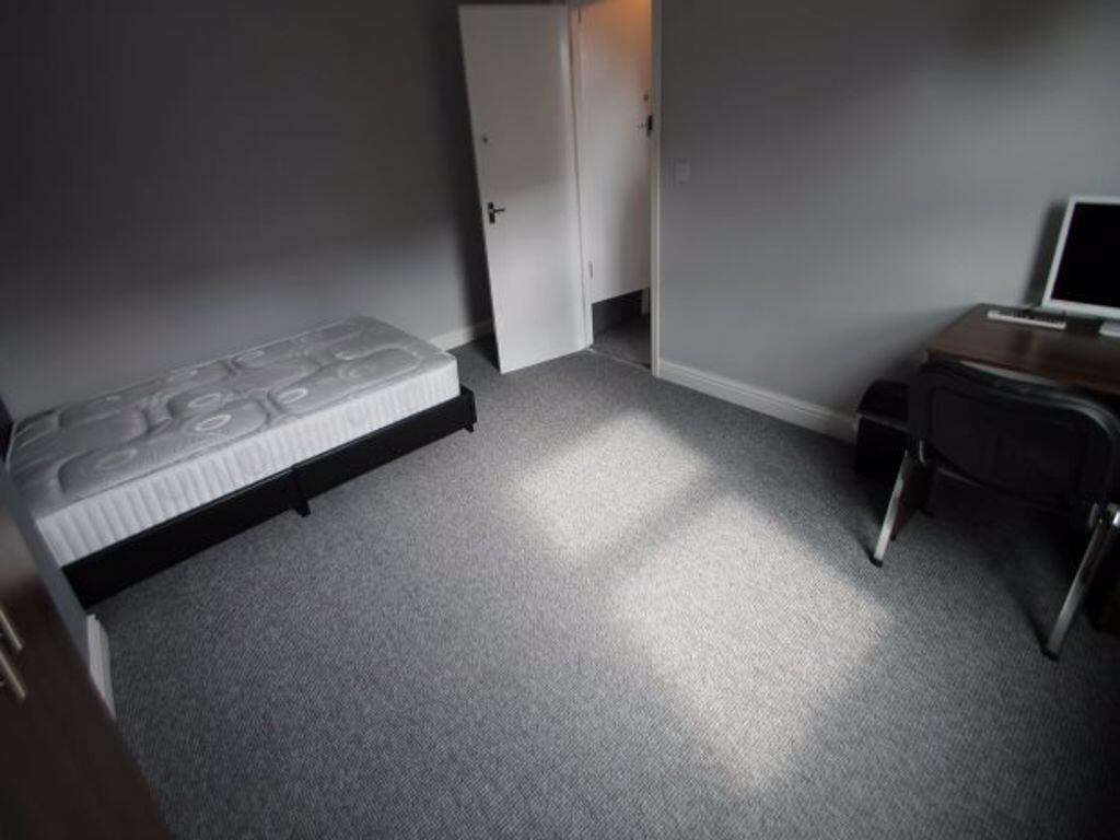 A tidy and minimalistic single bedroom with a s...