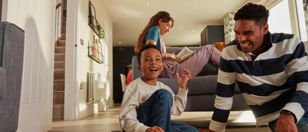 Happy family enjoying quality time together in a bright living room with large window, sofa, and mod
