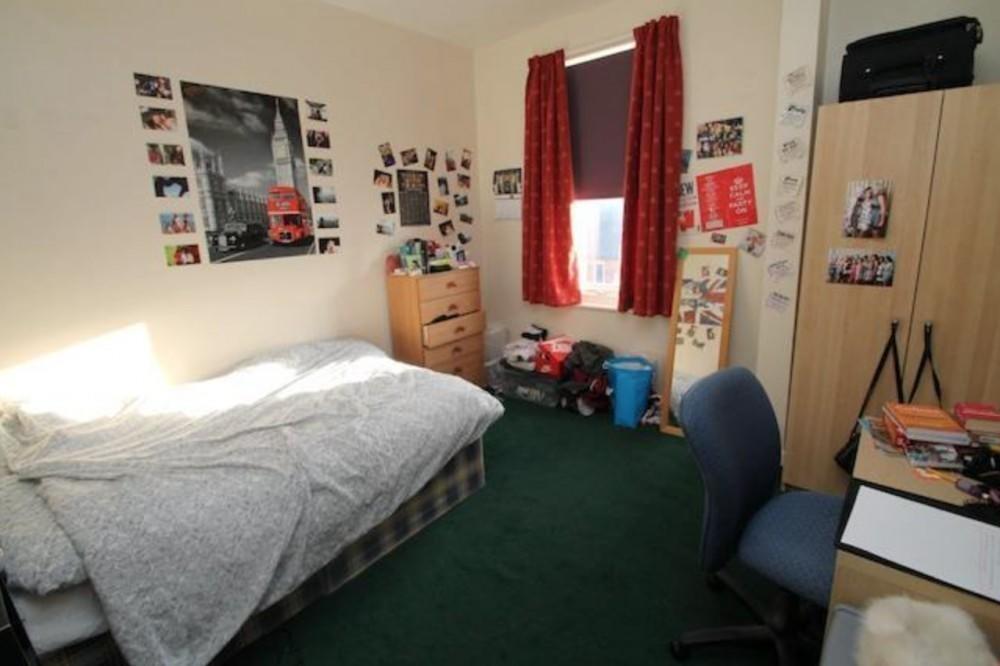 Cozy single bedroom featuring a comfortable bed...