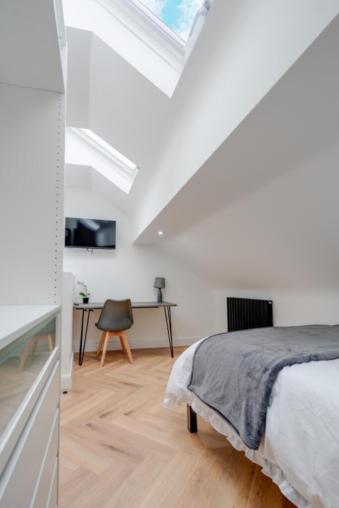 A bright and modern double bedroom featuring st...