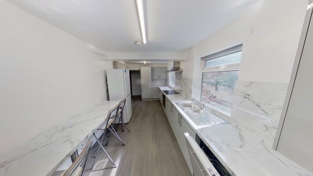 A modern kitchen featuring sleek marble-effect ...