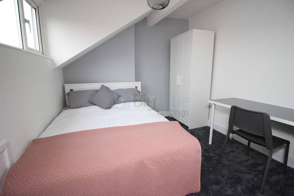 Bright and cozy bedroom featuring a comfortable...