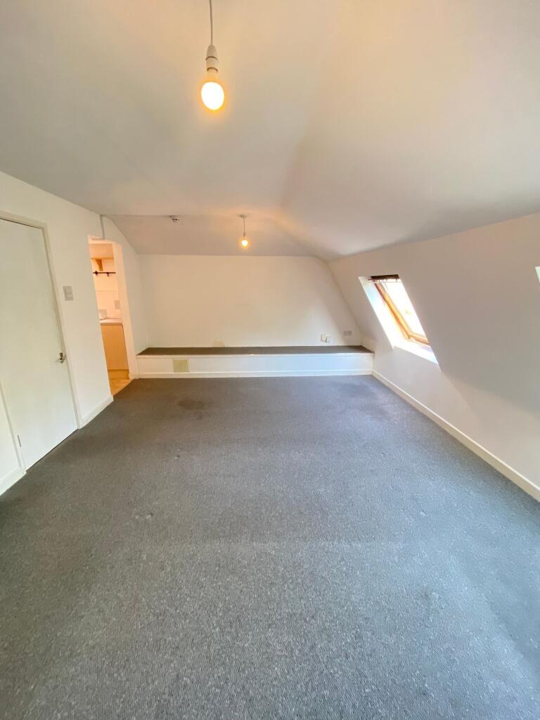 A spacious living room with neutral walls and c...