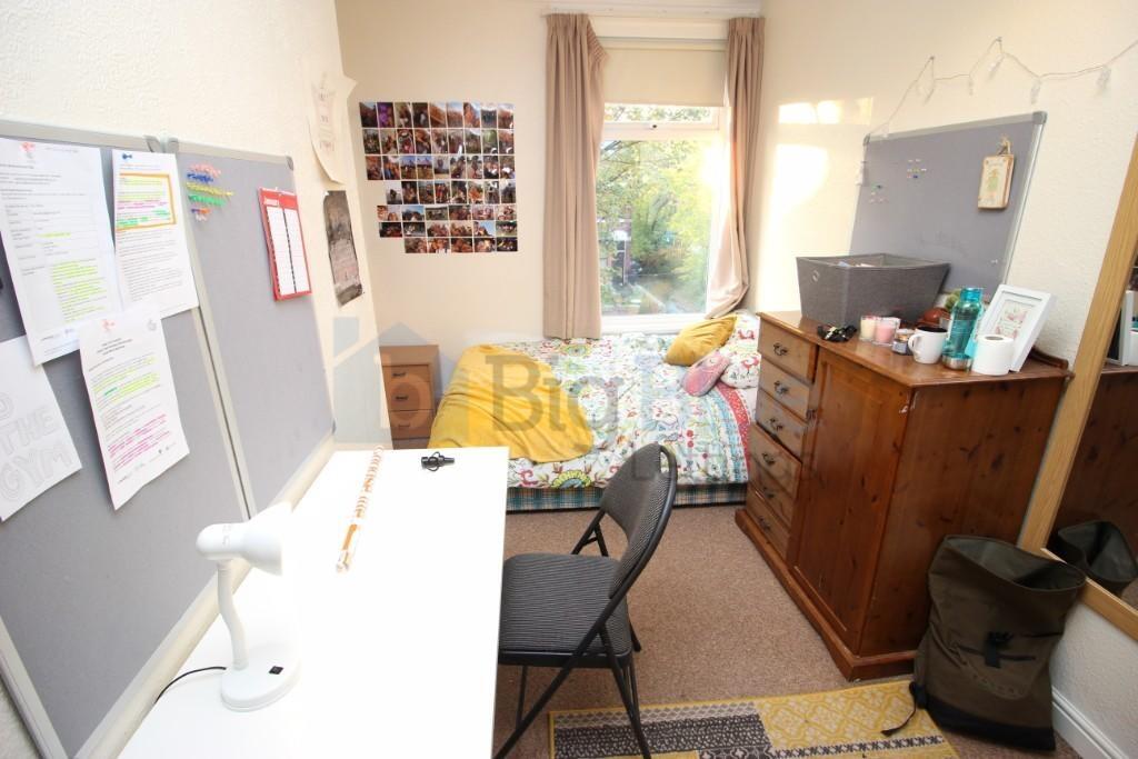Cozy single bedroom featuring a bright window w...