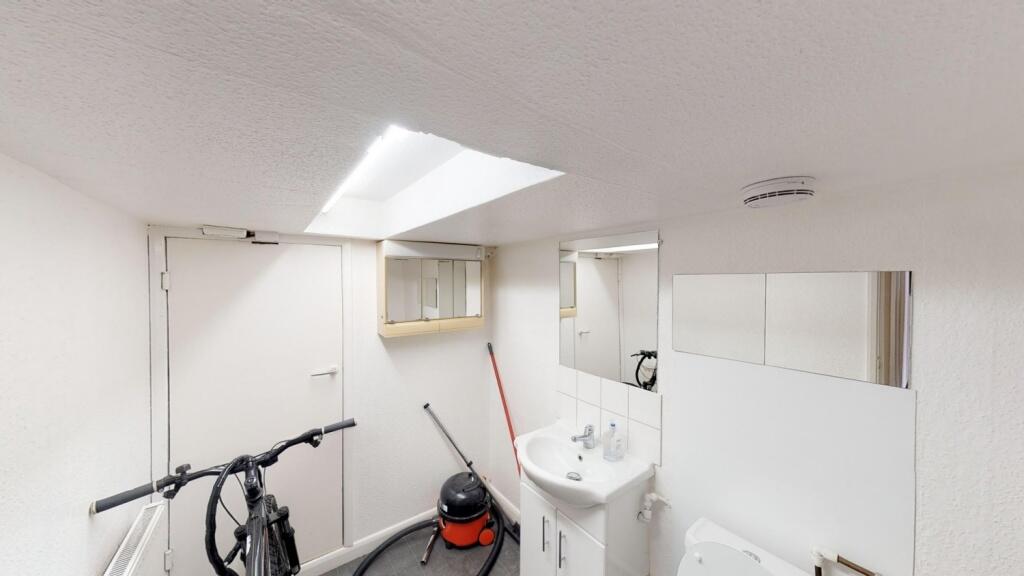 A compact, clean bathroom featuring a white sin...