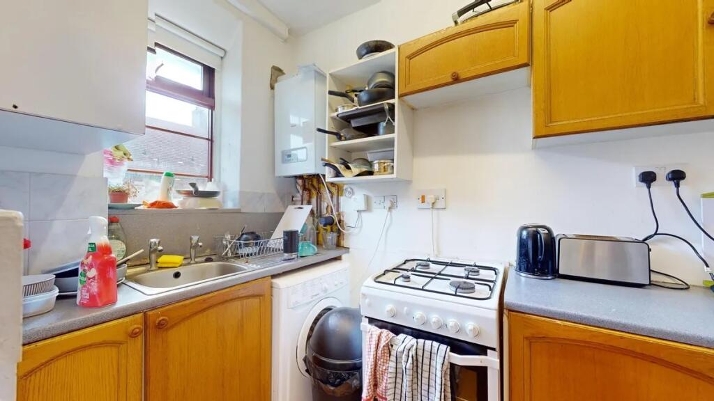 Compact kitchen featuring wooden cabinetry and ...