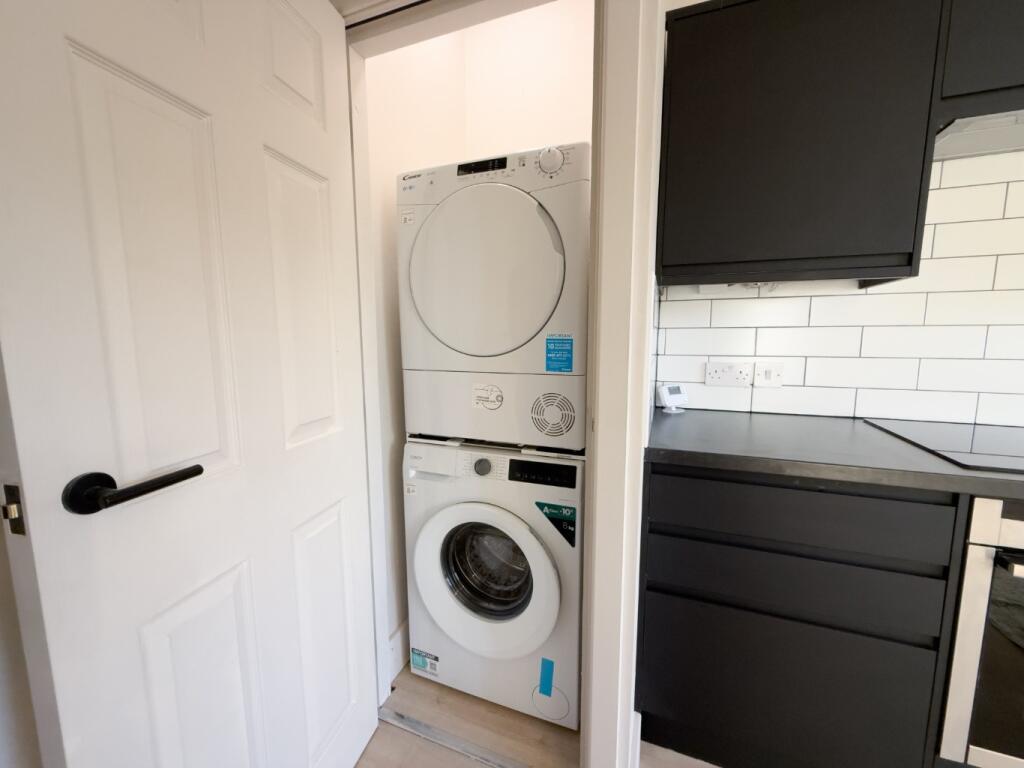 Compact modern kitchenette with integrated stac...