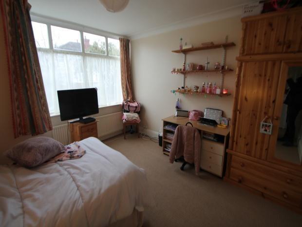 A cozy bedroom featuring a double bed, a wooden...