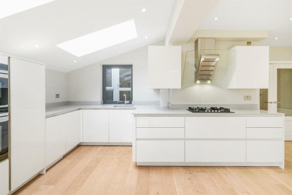 White laquerd kitchen with marble worktops