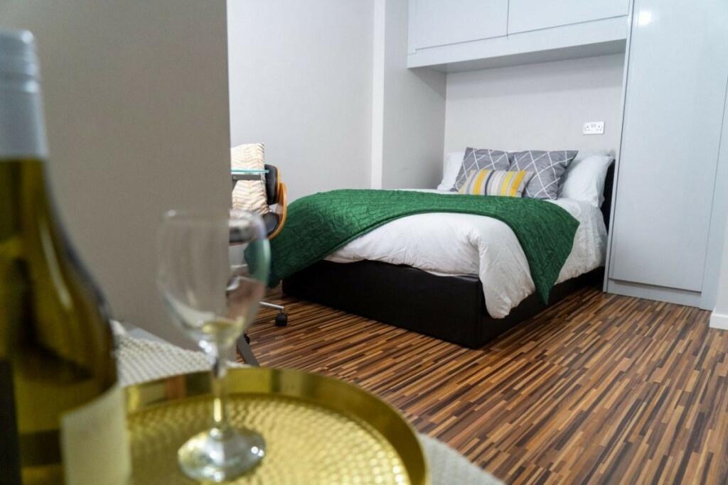 A spacious master bedroom featuring a comfortab...