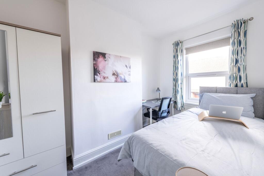 Bright and welcoming double bedroom featuring a...