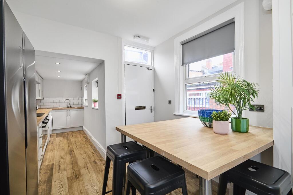 Bright, modern kitchen with wood-style flooring...