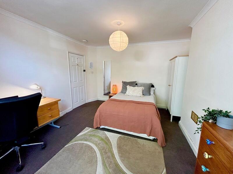 This inviting double bedroom features a comfort...