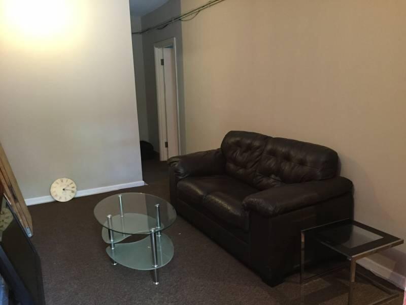 A comfortable living room featuring a dark leat...