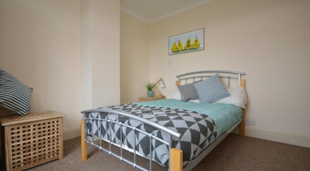 A cozy double bedroom featuring a comfortable b...