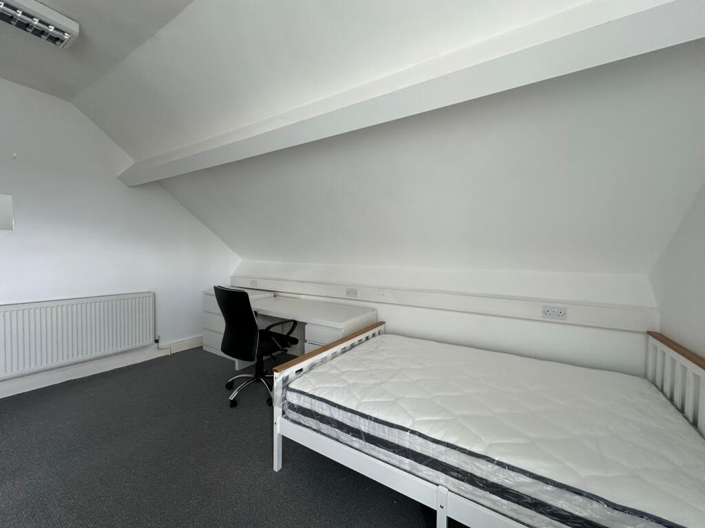 A clean and simple single bedroom featuring a w...