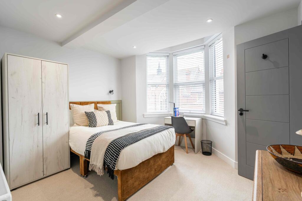 A bright and inviting bedroom featuring a doubl...