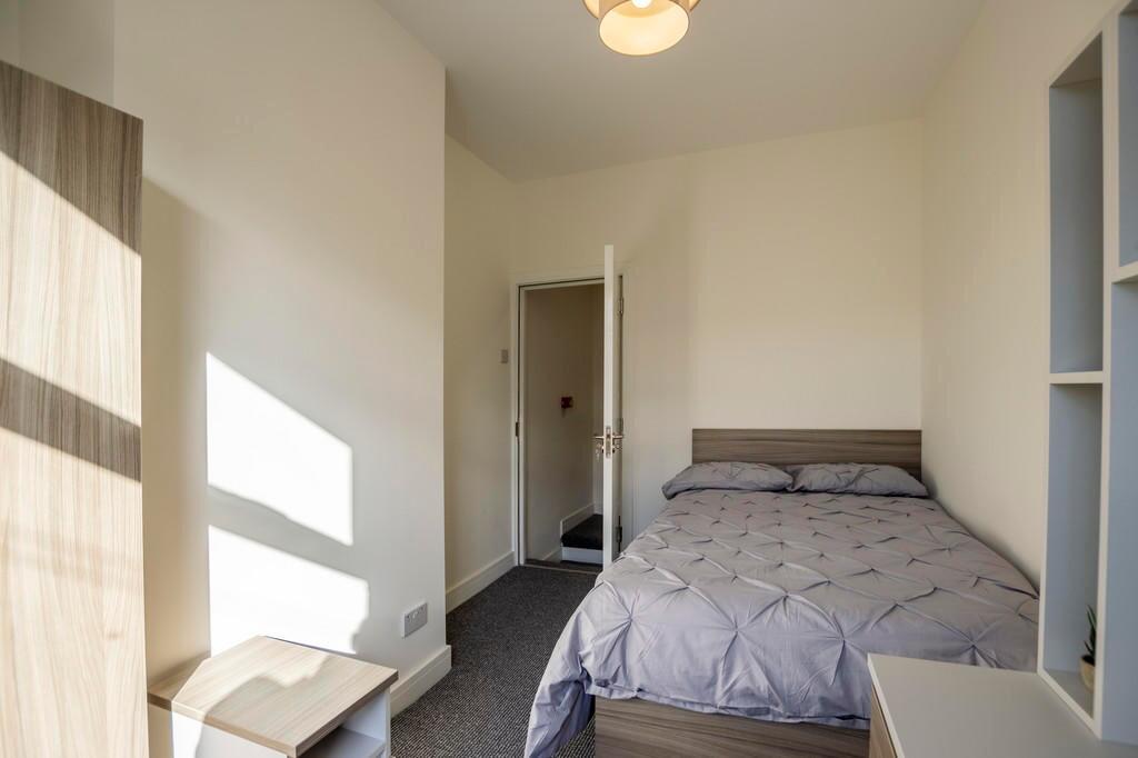 Bright and welcoming double bedroom featuring a...