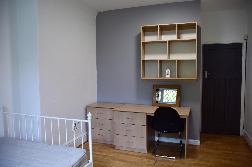 A neatly maintained student bedroom featuring a...