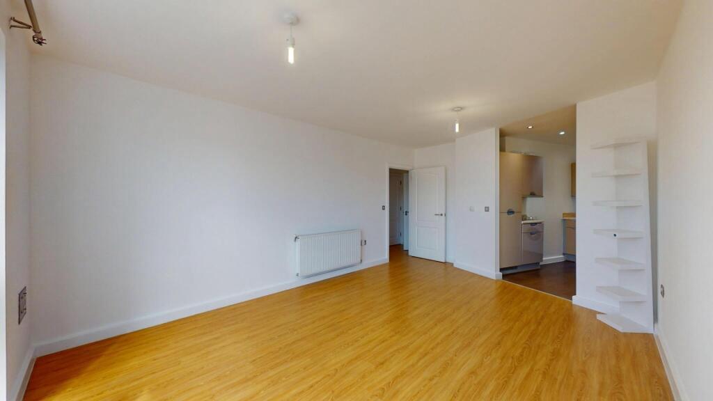 A bright and spacious living room featuring cle...