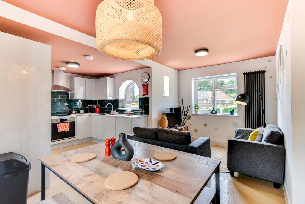 A modern open-plan living room and kitchen area...