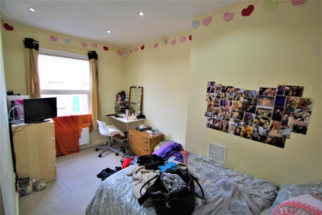 Cozy single bedroom featuring a large window wi...