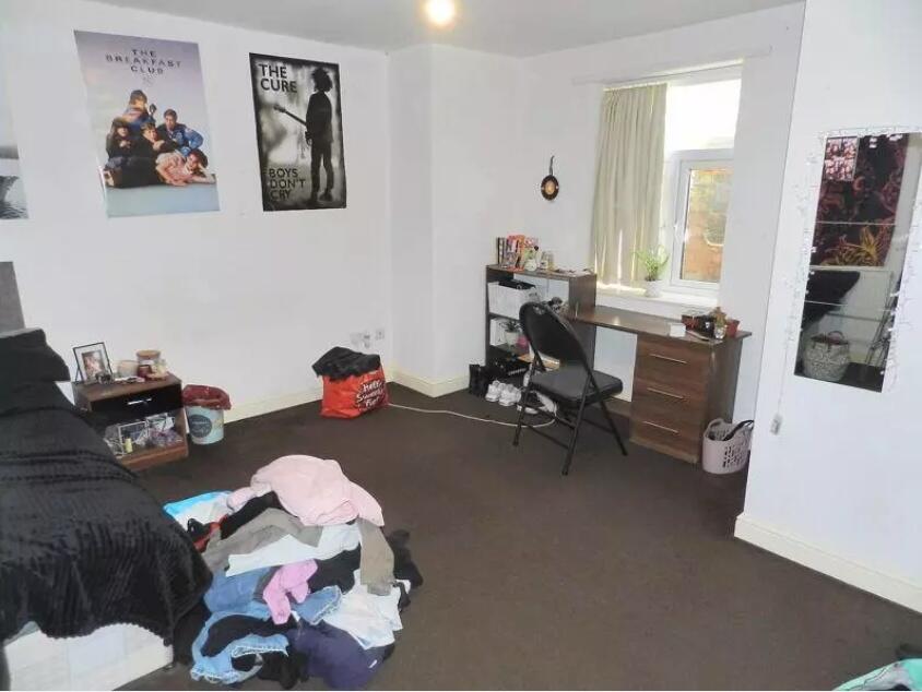 A modestly sized bedroom with neutral decor fea...