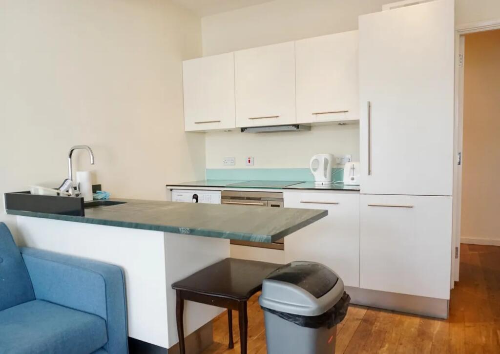 A modern and clean kitchen area featuring white...