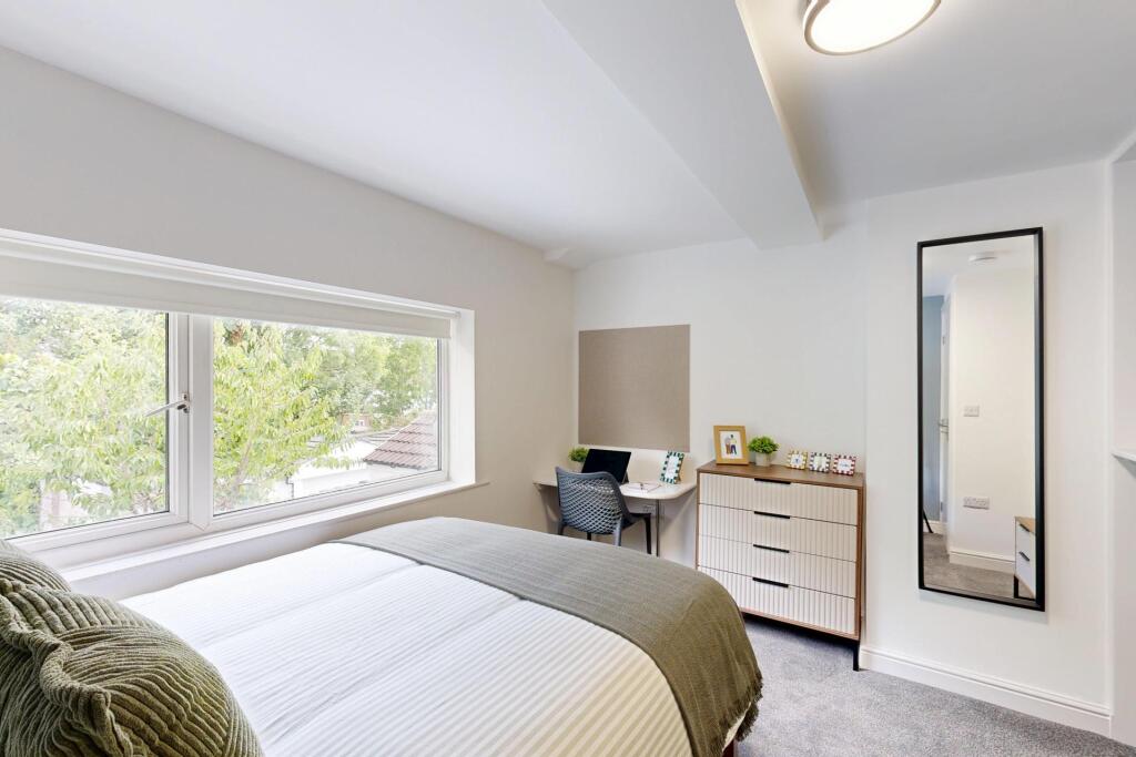 A bright and inviting bedroom featuring a large...