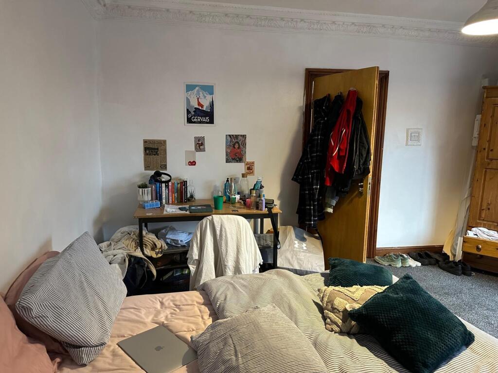 A cozy bedroom featuring a double bed, some per...