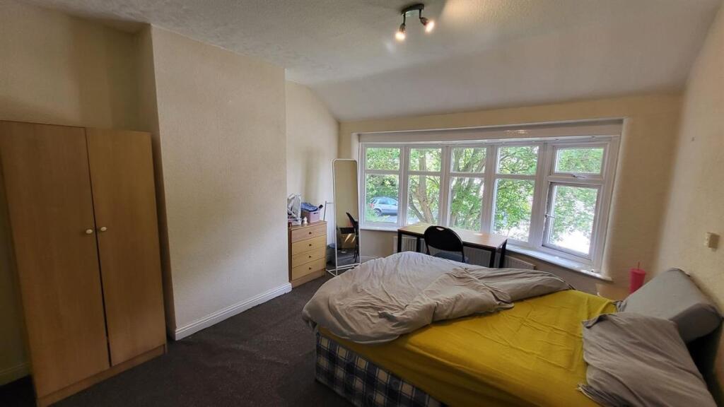 A bright double bedroom featuring a large bay w...