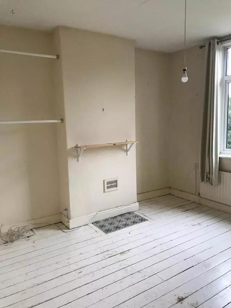 A modestly sized bedroom with natural light com...