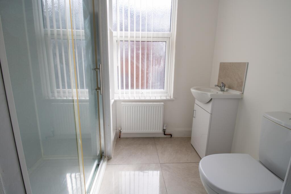 A clean and well-lit bathroom featuring a toile...