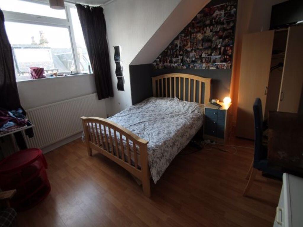 Cozy double bedroom featuring a wooden bed fram...
