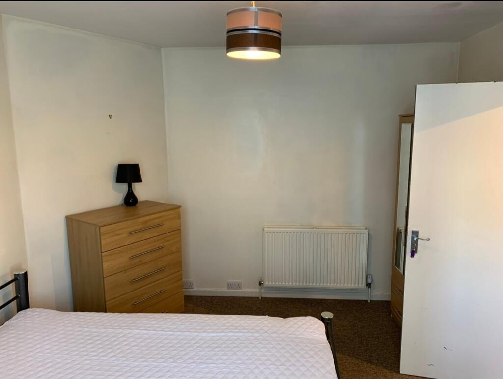 A bright and tidy double bedroom featuring a st...