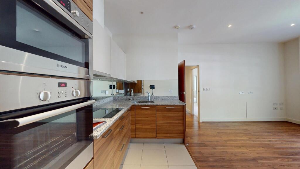 Modern kitchen with sleek wooden cabinetry, bui...
