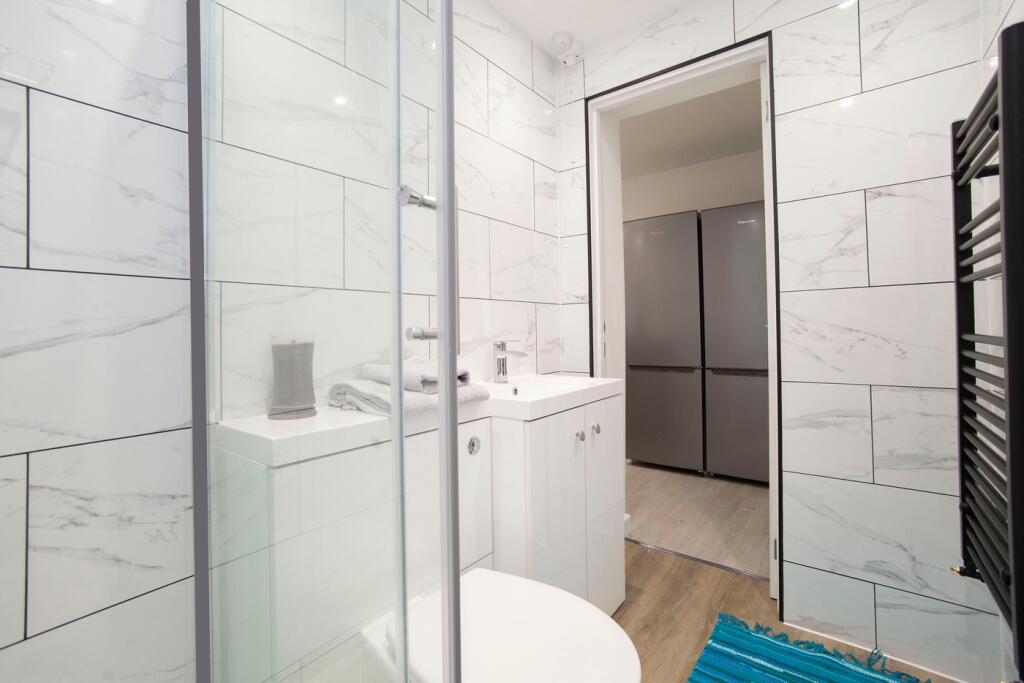 A modern and clean bathroom featuring a glass s...