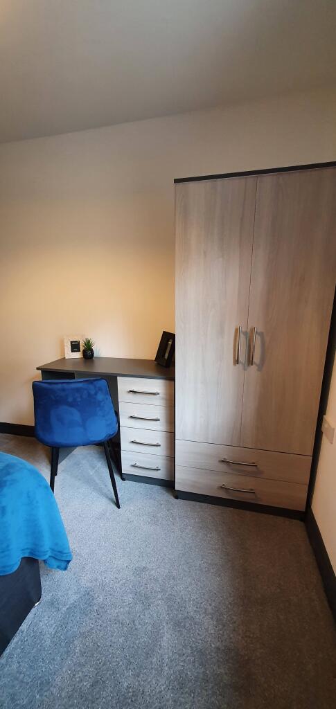 Cozy double bedroom featuring a stylish desk an...