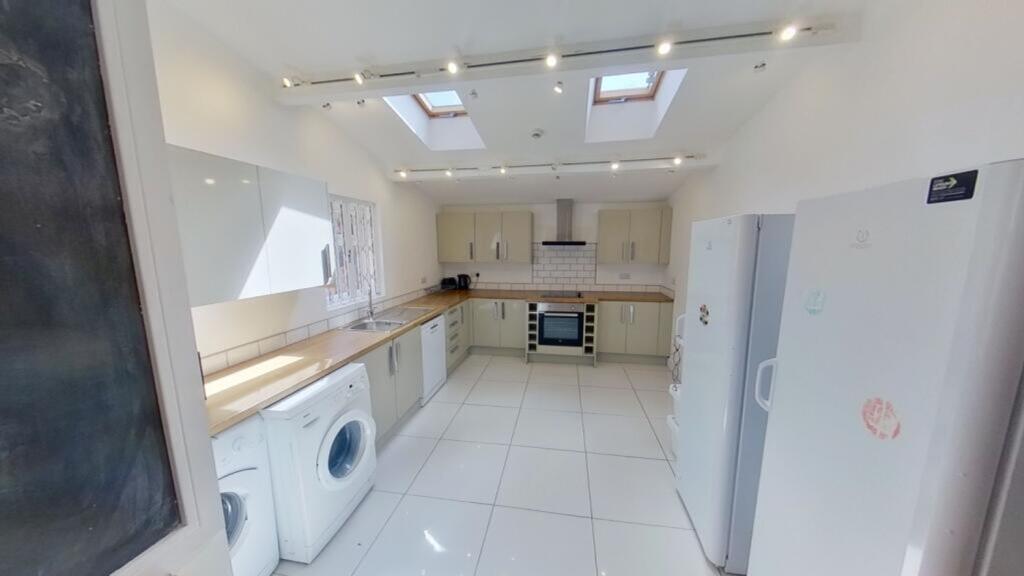 A spacious and modern kitchen with abundant nat...