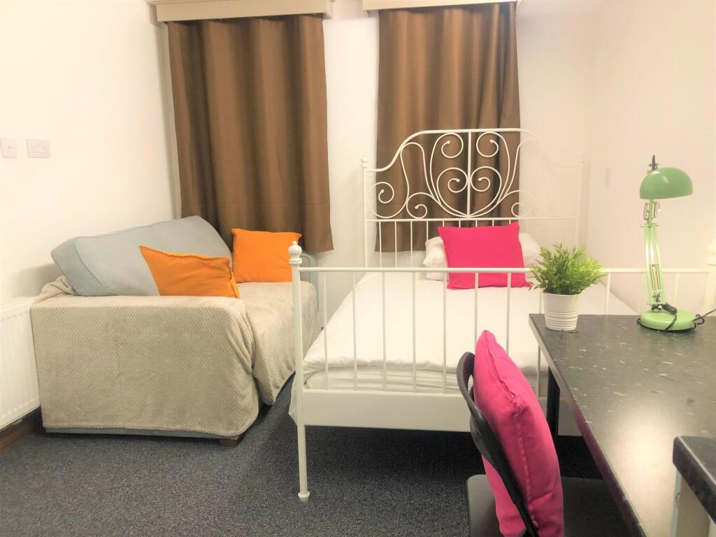 A cozy and well-kept single bedroom featuring a...