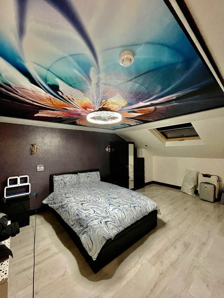 Spacious master bedroom featuring a striking ce...