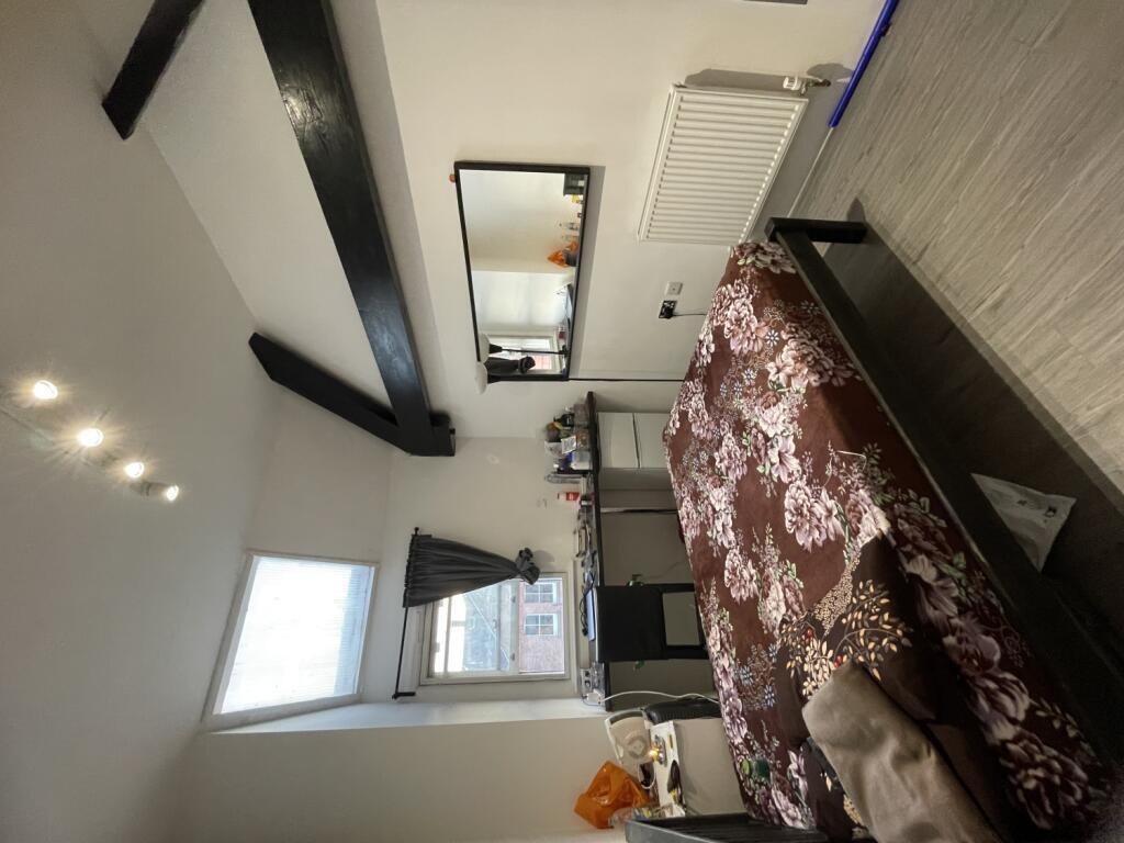 A cozy double bedroom featuring exposed ceiling...