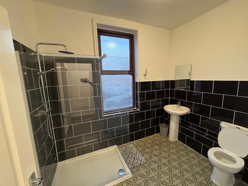 A modern bathroom featuring a walk-in shower wi...