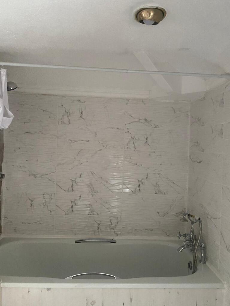 A clean, modern bathroom suite featuring a whit...