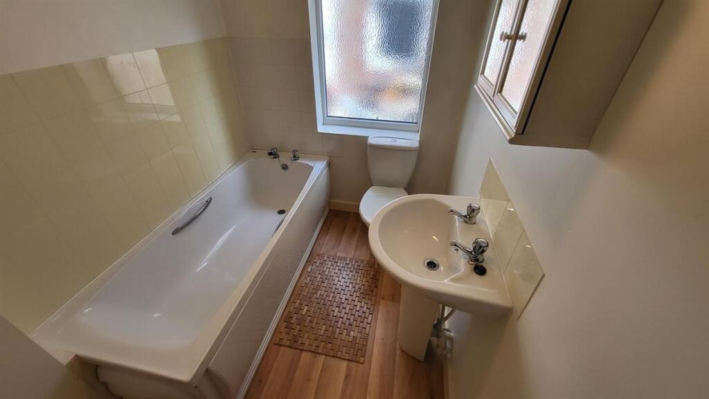 Bright and clean bathroom suite featuring a ful...
